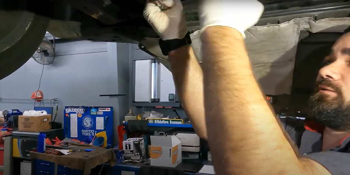Tommy removing drain plug with 19mm wrench