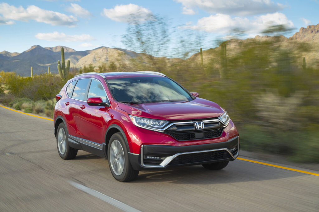 2020 Honda CR-V Hybrid driving on a scenic desert highway with mountains in the background