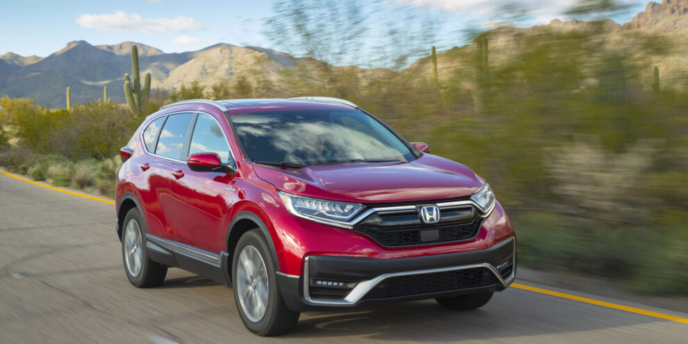 2020 Honda CR-V Hybrid driving on a scenic desert highway with mountains in the background